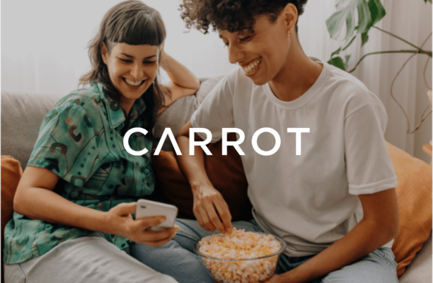2 people sitting on a couch and eating popcorn with a text Carrot