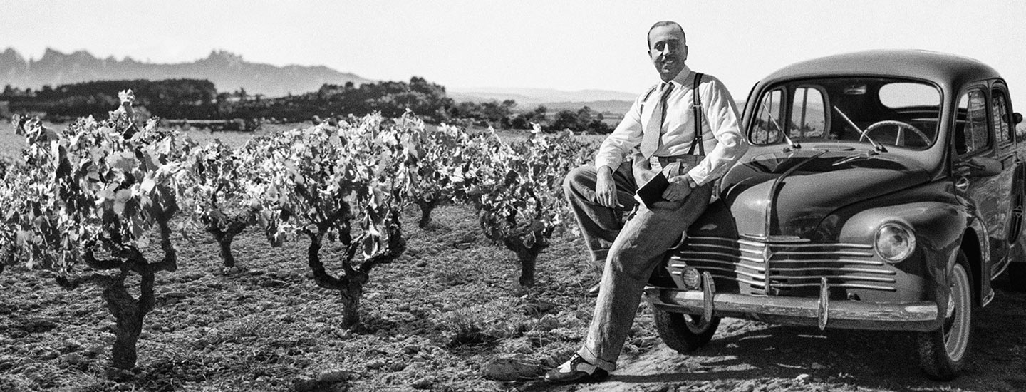 Miguel Torres Carbó in a vineyard with his car, now displayed at the family museum, where he always kept a bottle of wine to show people