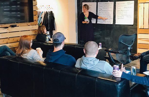 A woman explaining something on the board and group of people listening