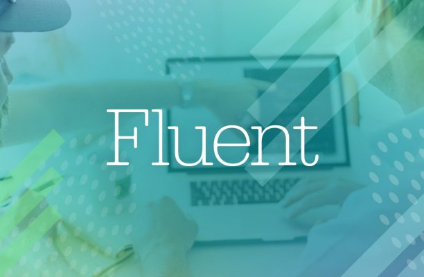 Two persons looking at a laptop with the word fluent