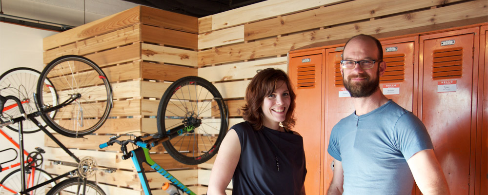 Two people standing in front of a room full of bicycles